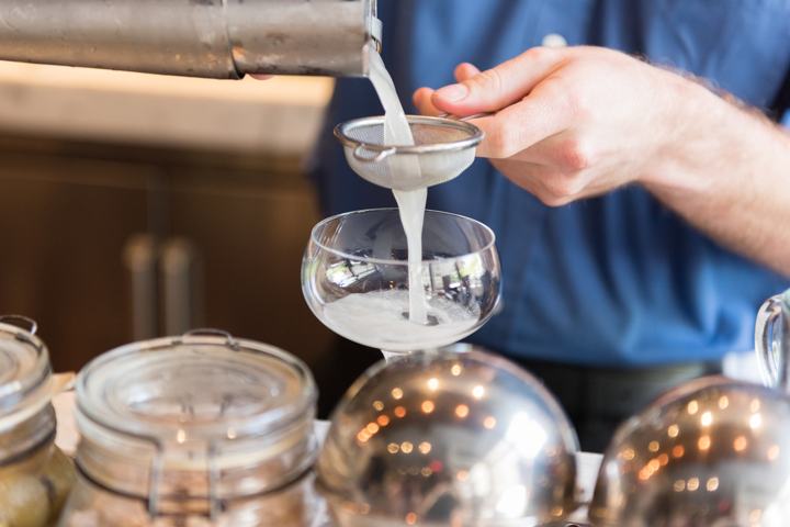 Bartender straining cocktail